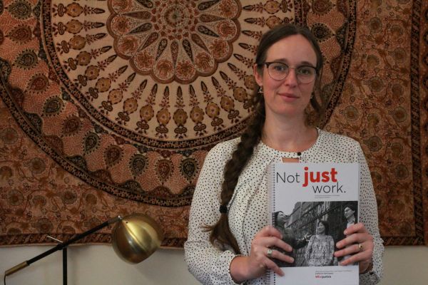Photograph of Catherine Hemingway holding the Not Just Work Report