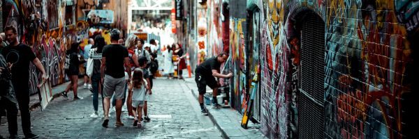 People walking in a graffiti lined laneway in Melbourne