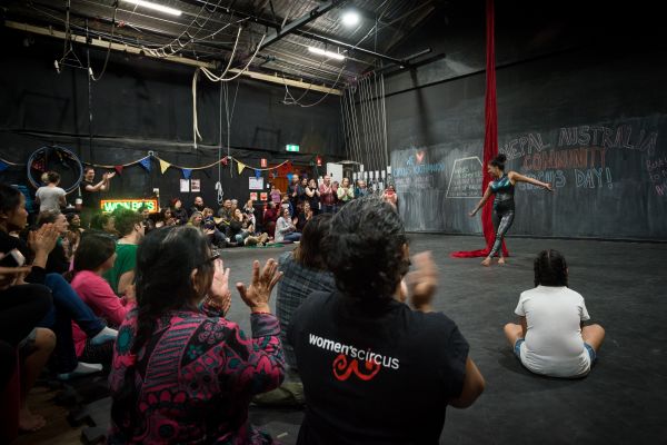 Photograph of a circus performance in a large warehouse space
